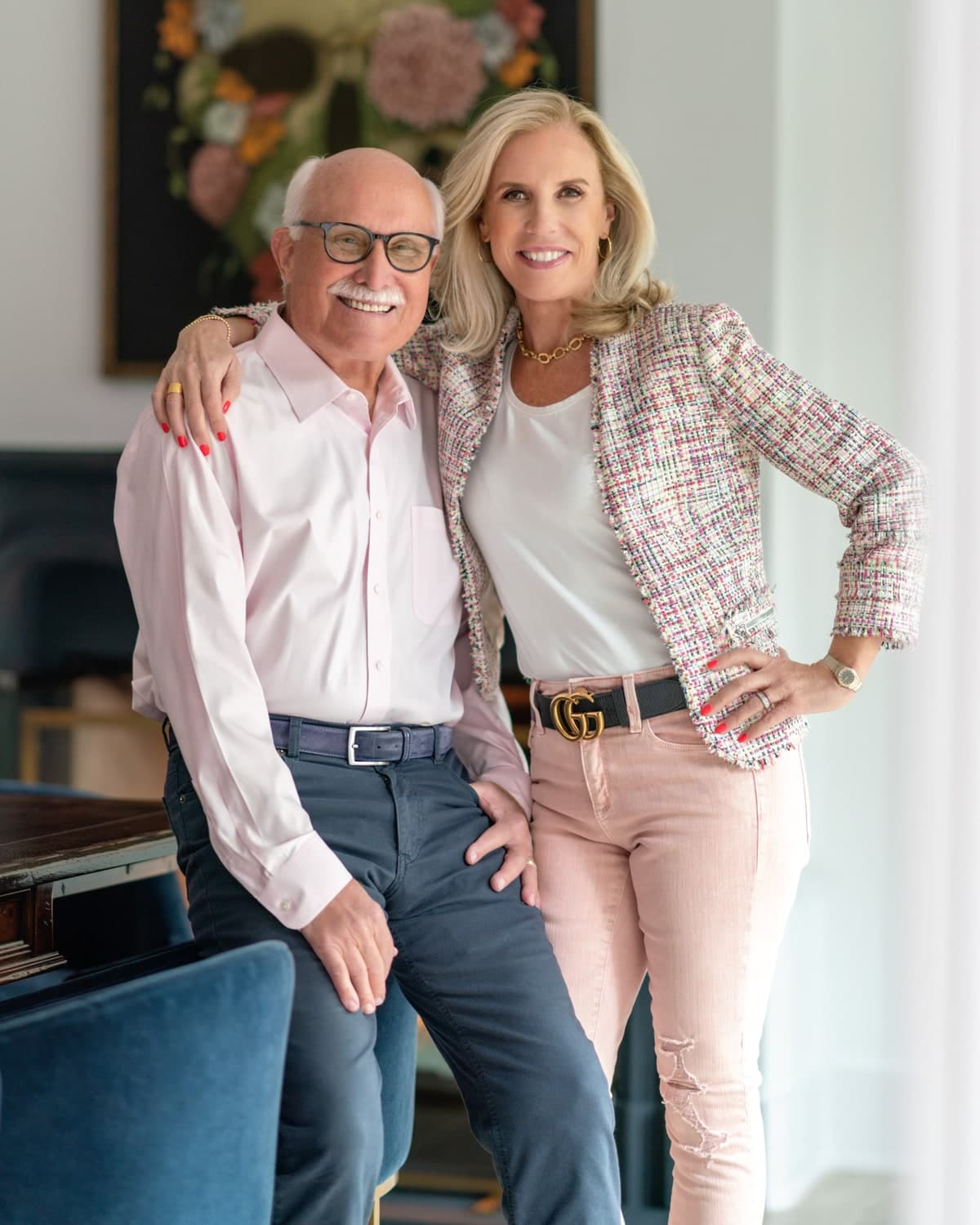 Ann Marie Nugent and Jim Walberg standing together indoors, in front of a floral artwork.