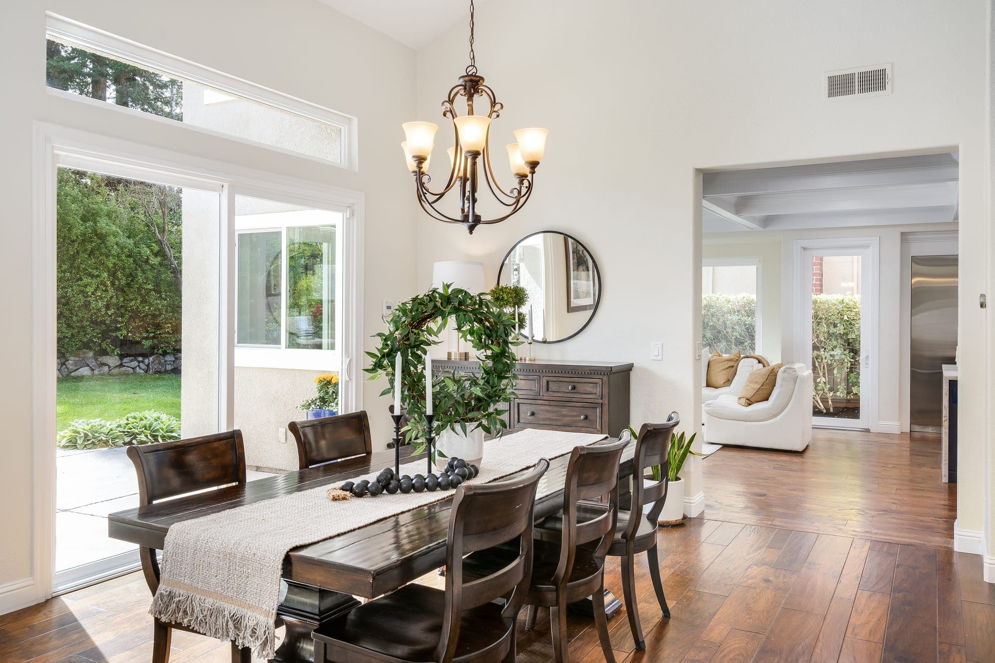 The dining room with a chandelier and sliding glass doors to the backyard.