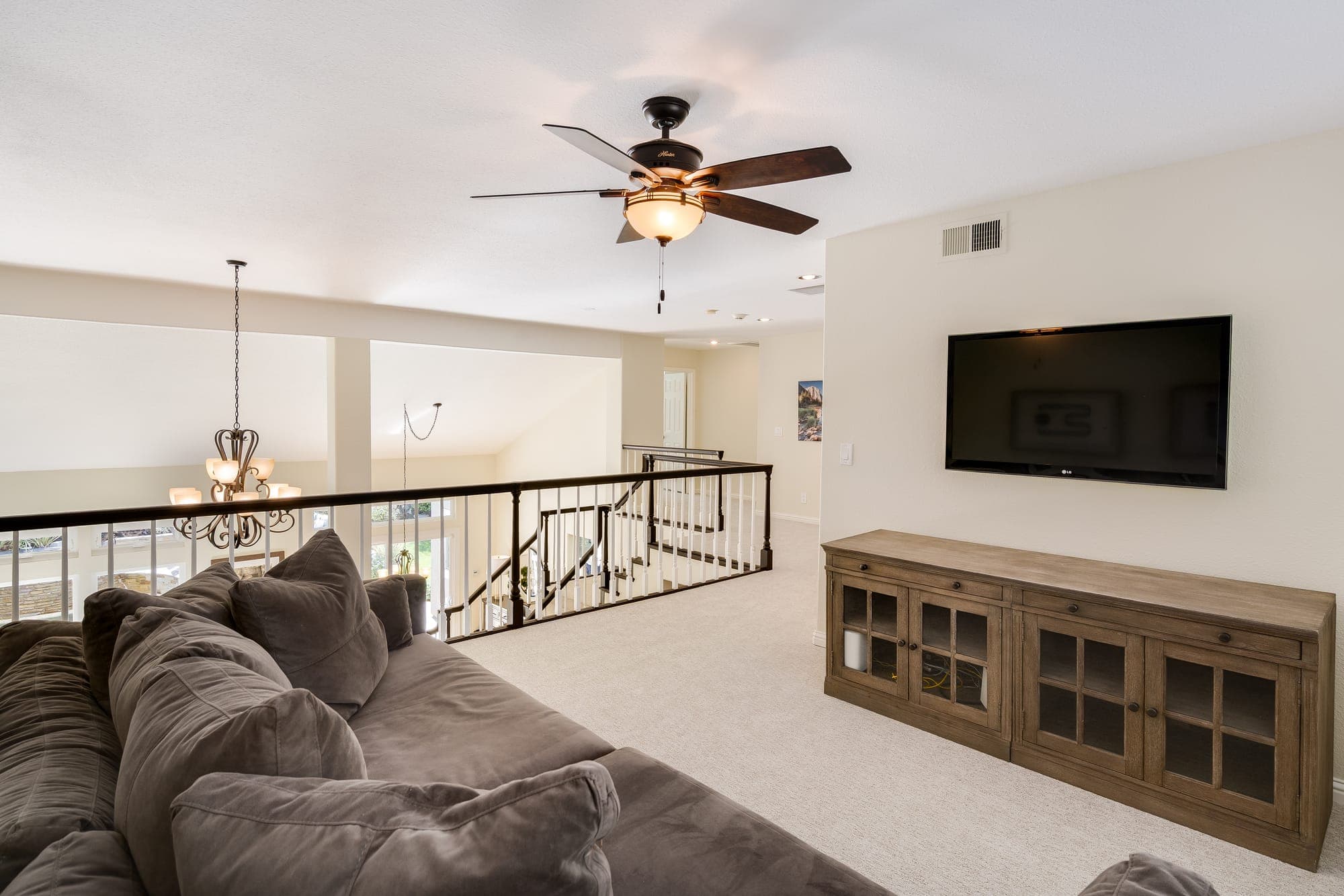 The upstairs loft with a media wall, open to the stair and entry below.