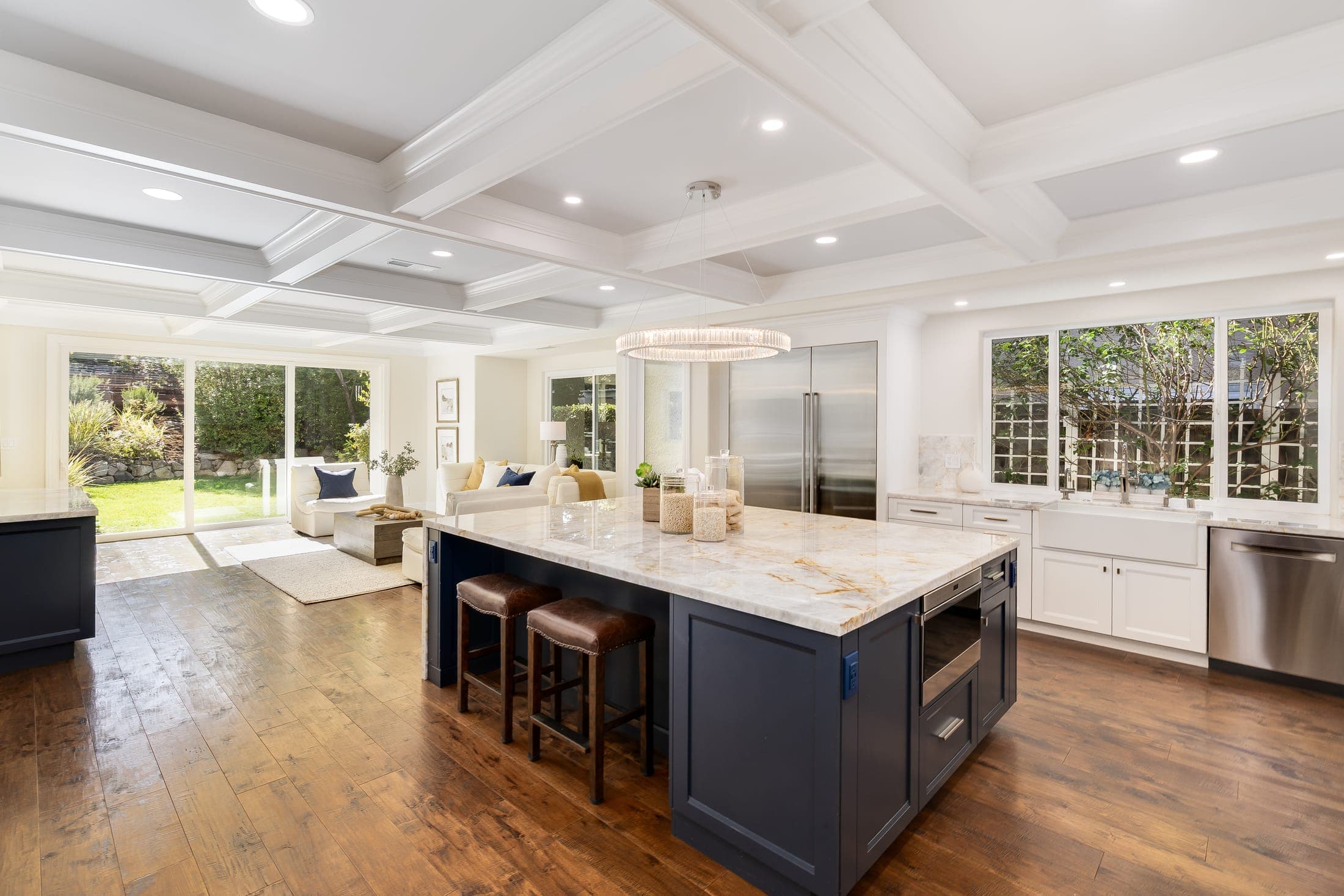 The kitchen island with stools, looking across to the family room and backyard.